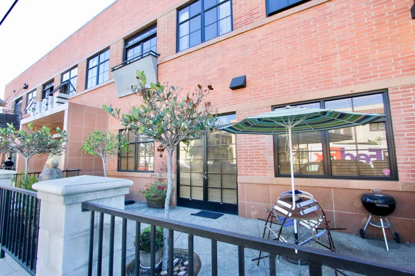 A sunny day in the Cable Building Lofts with residential building and plants.