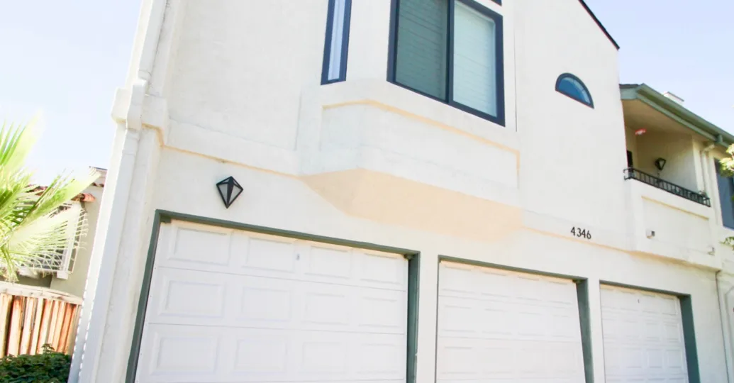 Exterior of a Campus Park apartment unit with private garages and a second floor balcony.