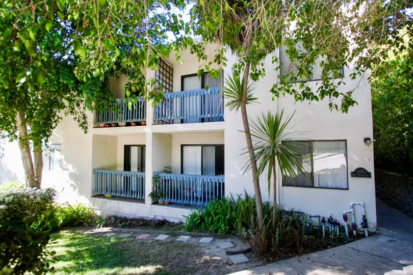 House with a beautiful lawn and balconies with trees in Canyon Shadows of Hillcrest