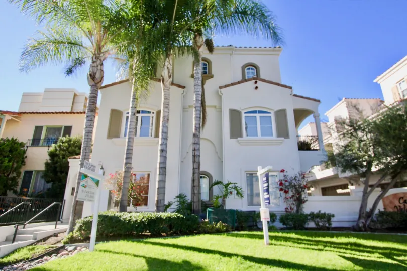 A traditional three-storey residence with large trees in the front yard in Casa Valencia community.