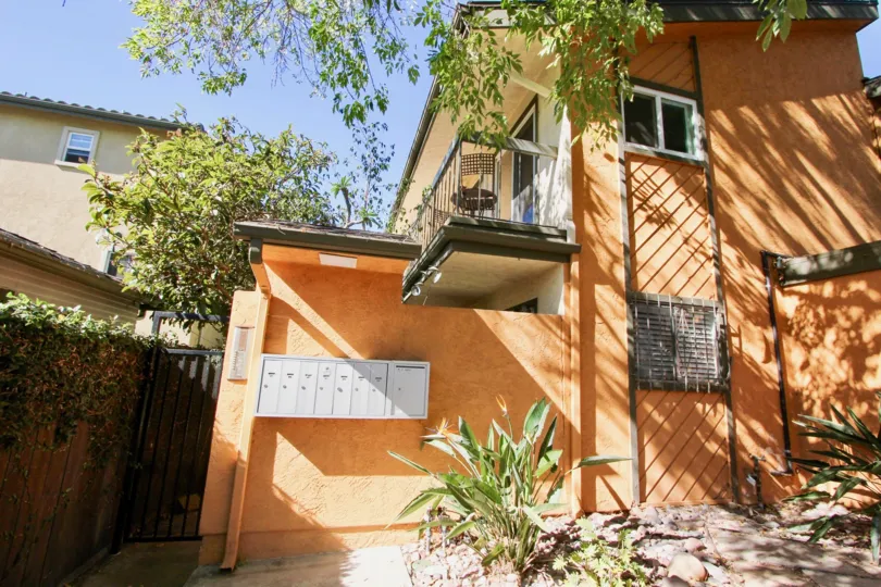 A two-storey apartment with black gate and orange walls in the Centre St neighborhood.