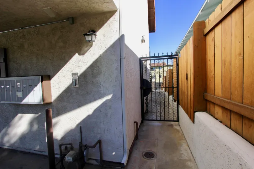 A sunny day in the area of Chateau Centre, outside, wooden fence, gate, sidewalk, mailboxes