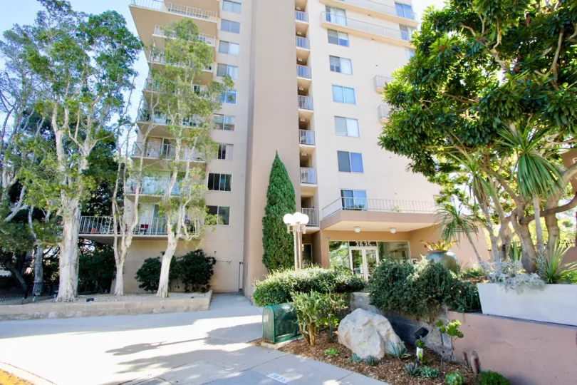 Large apartment building on sunny day in Coral Tree Plaza in Hillcrest, CA