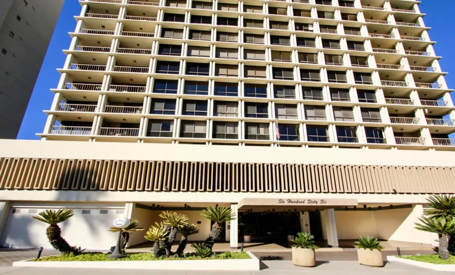 A mid-rise townhouse in the Del Prado community with podium parking and individual balconies.