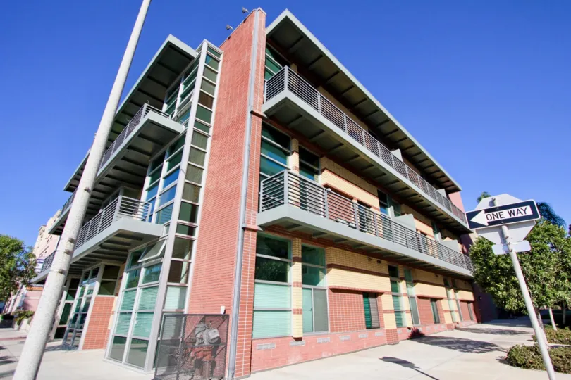 A sunny day in the Fifth Avenue Lofts with residential building and a sign.