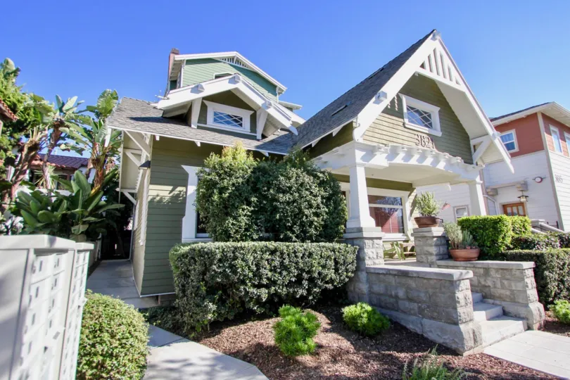 A green home with white trim in the community of Heritage on First of Hillcrest California