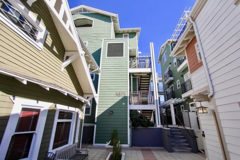 A sunny day in the Heritage on First with residential building and plants.
