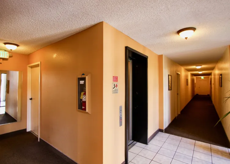 A corridor inside a building in the Mission Crest Gardens with lights.