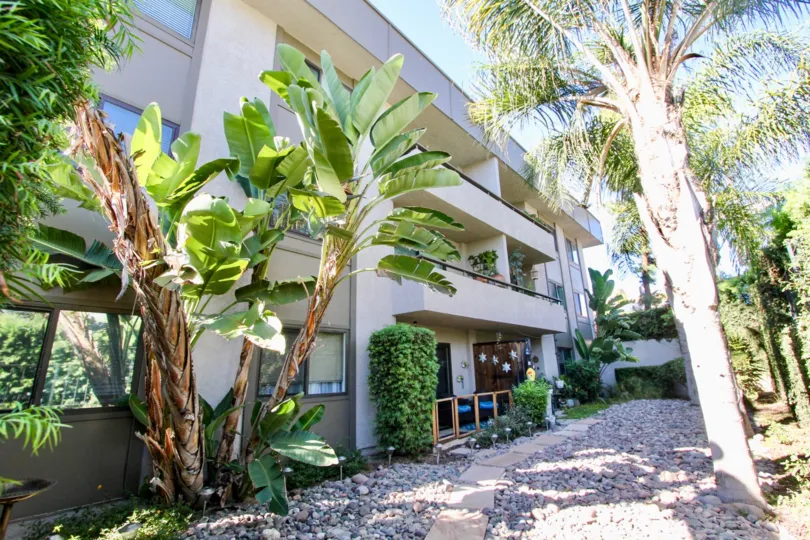 A three-storey townhomes with a stony path in the Mission Crest Gardens