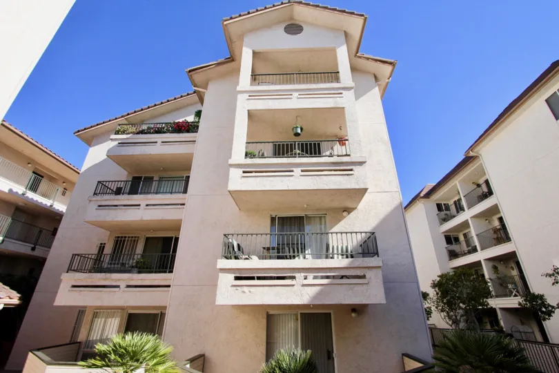 Balcony in Apartment of Pacific Ridge has flower pots, bushes and chairs