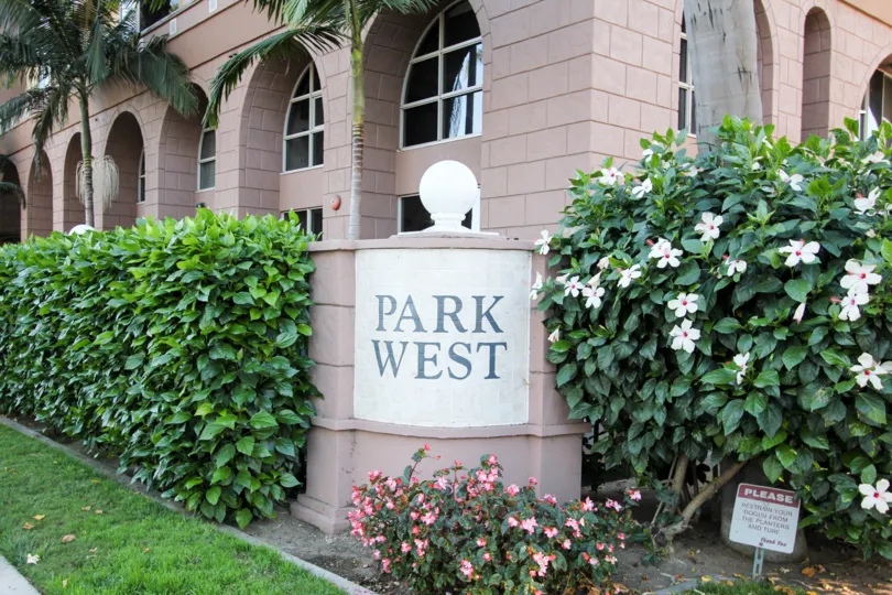 THE BUNGALOW IN THE PARK WEST WITH THE FLOWER PLANTS, TREES, LAWN