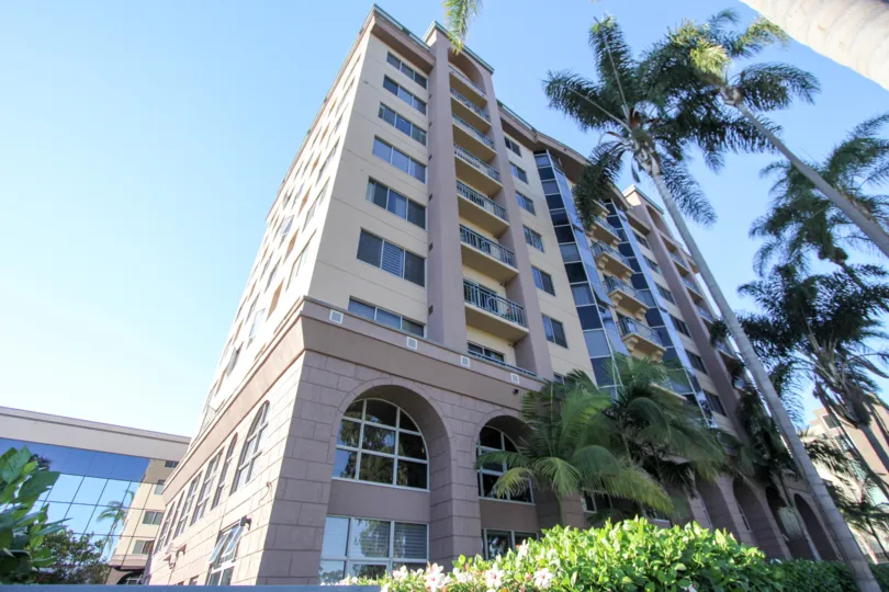 The tall Park West with trees on front end of the building