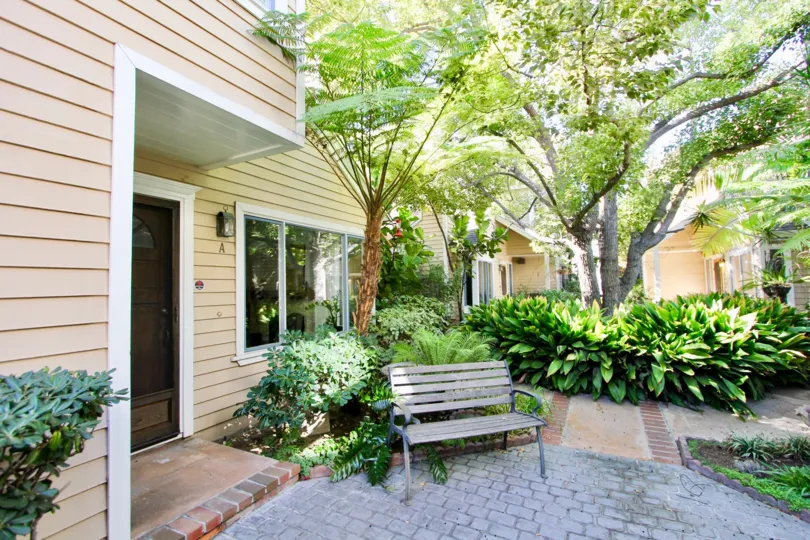 Quiet cozy courtyard with mature trees for shade and brick laid walkways in Hillcrest