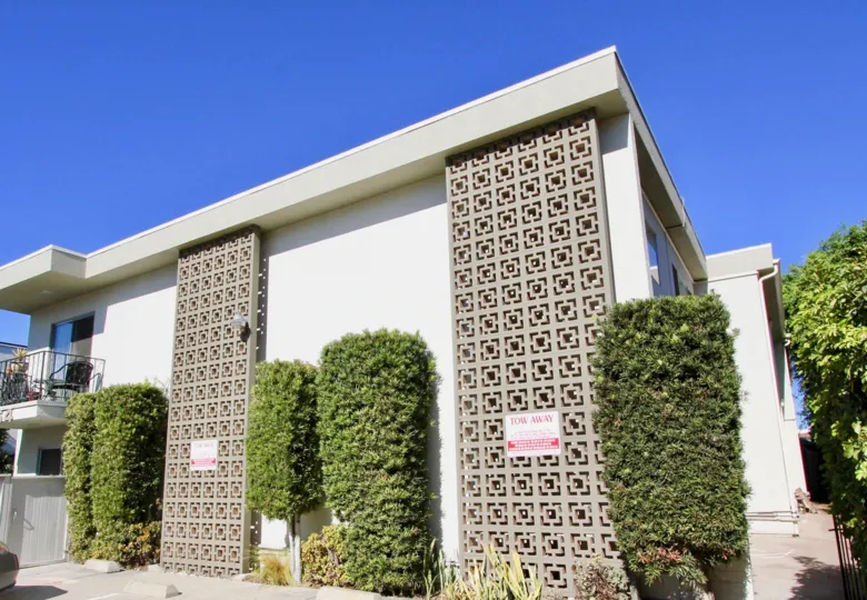 The front side of Robinson Ave Villa with green plants around the building