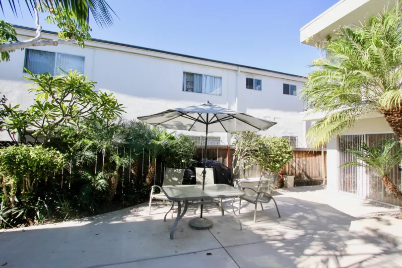 A sunny day in the Robinson Ave Villa with residential building and plants.