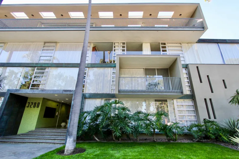 THE 3200 APARTMENT IN THE SOLOMON BUILDING WITH THE LAWN, PLANTS, TREES, BALCONIS