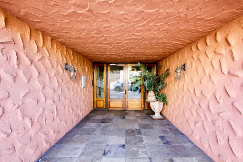 Flower pot is placed near the door and lamp is attached in wall of Villa in Terrace Village