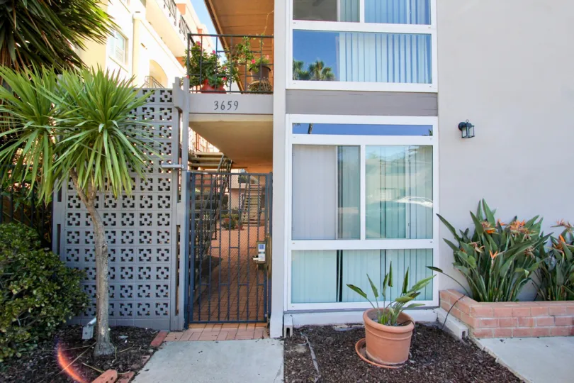 The cheerful, landscaped entryway to The Orleans in Hillcrest, CA