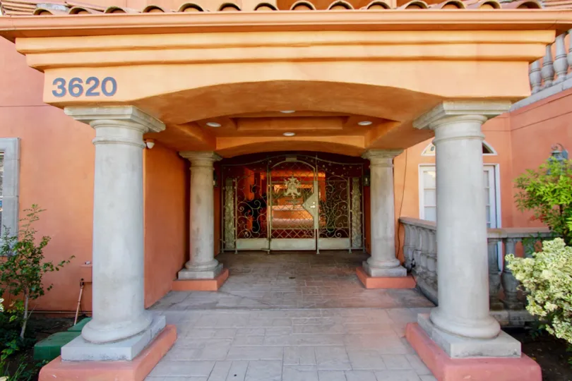 An entrance of a building in the Trevi Villa with beautiful plants.