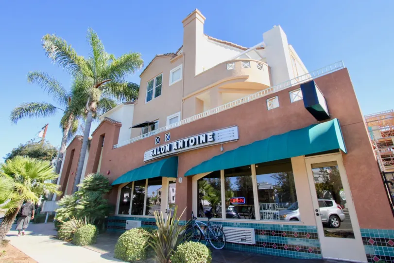 A sunny day in the DUptown Court with a store and plants.