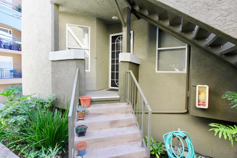 An entrance of a building in the Uptown Villas West with beautiful plants.