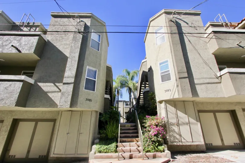 An entrance with a staircase in-between housing units in Uptown Villas West community.