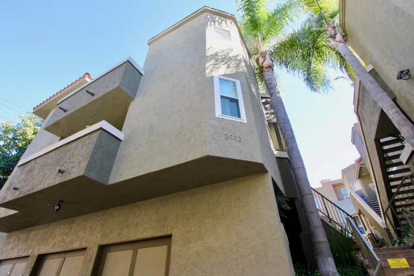 A 3 level home in Uptown Villas West on a sunny day with palm trees