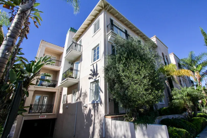 Ample of sunshine with palm trees in front of a multi story villa in Villa Portofino of Hillcrest
