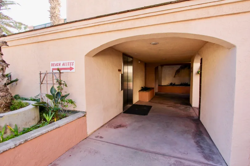 A hall with a sign saying "beach access" with some bushes on the side in Imperial Beach Club, Imperial Beach, CA