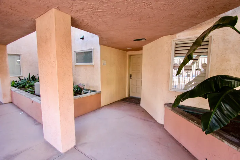 The door to an apartment, with a short hallway and some bushes to the sides at Imperial Beach Club, Imperial Beach, CA