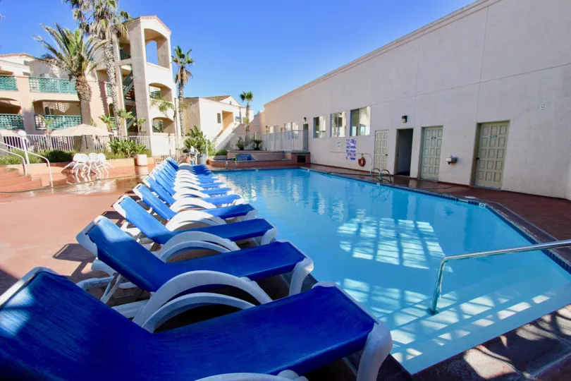 Swimming pool with lawn chairs near residence at Imperial Beach Club in Imperial Beach California