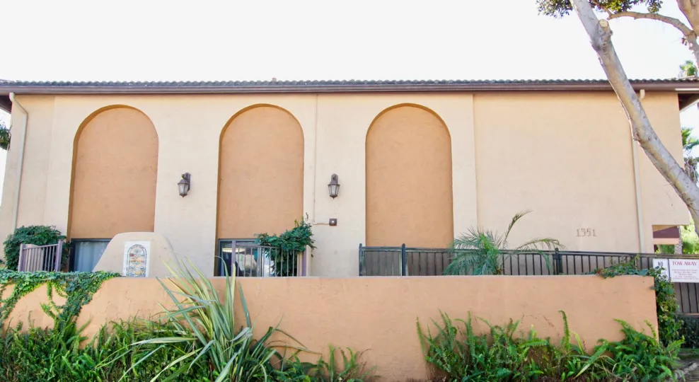 Back of a building with arch details and landscaping in On Holly