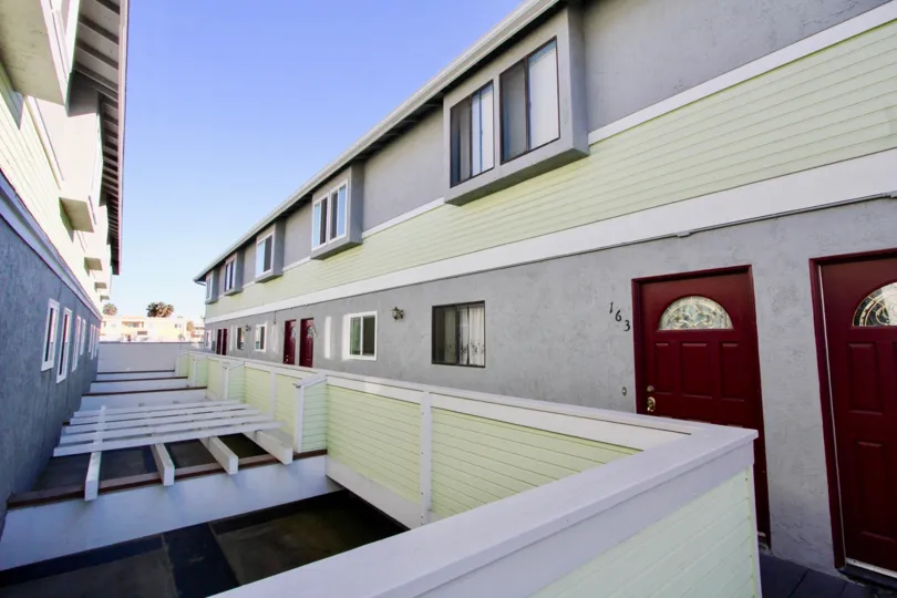 Residential units with reddish brown doors at Palm Plaza in Imperial Beach CA