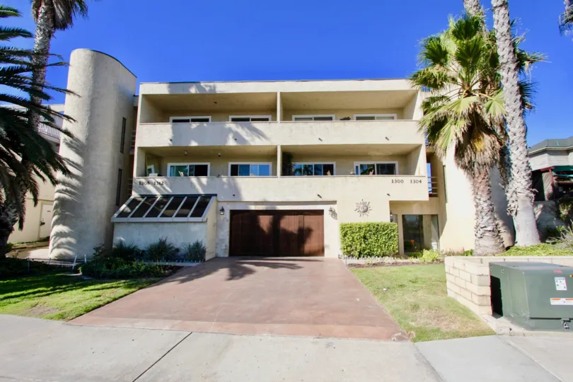 Three story garage with brown garage door and pink driveway at Peerless Shores in Imperial Beach CA