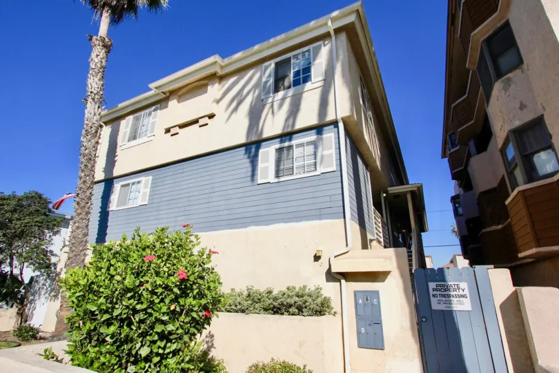 Three story residential building with blue gate at Playa Date in Imperial Beach California