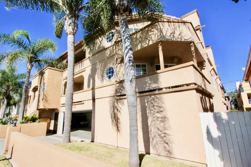 A peach color house with some palm trees in front during a sunny day in Playa Flores, Imperial Beach, CA