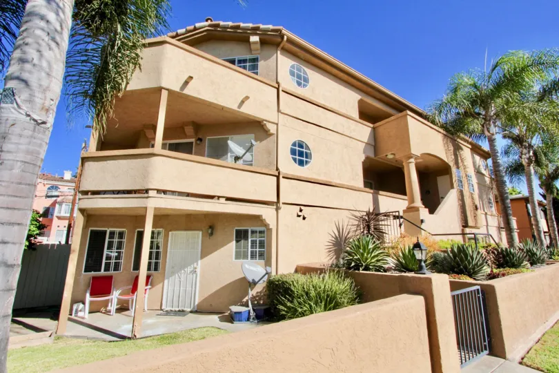 A big, peach color house with some palm trees in front during a sunny day in Playa Flores, Imperial Beach, CA
