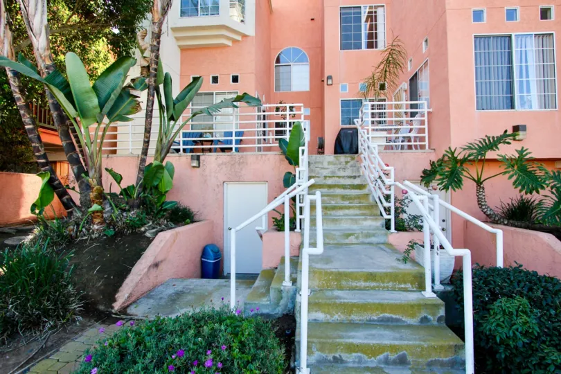 The Front yard of the beautiful pink-structured house with a lot of windows.