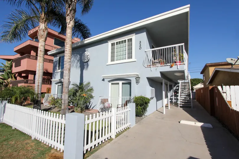Blue condominiums with balconies and walkway at Shauna Shores in Imperial Beach CA