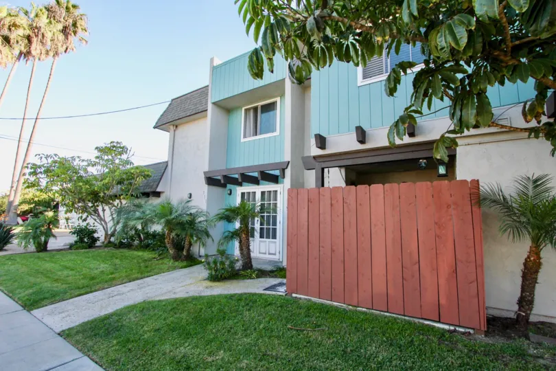 sunny day and palm trees, turquoise townhouse in the community of Silver Strand Gardens