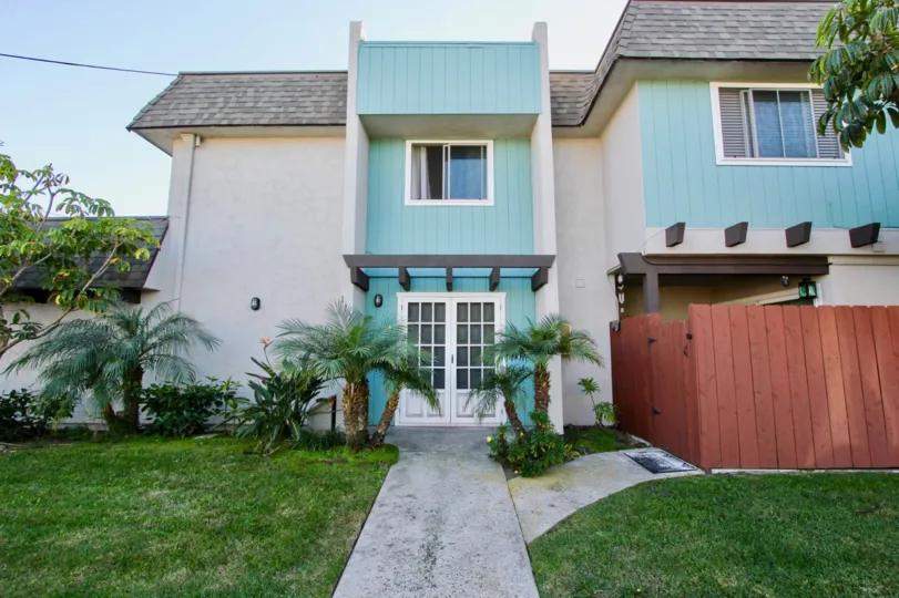 Two story housing with white doors and a yard at Silver Strand Gardens in Imperial Beach California