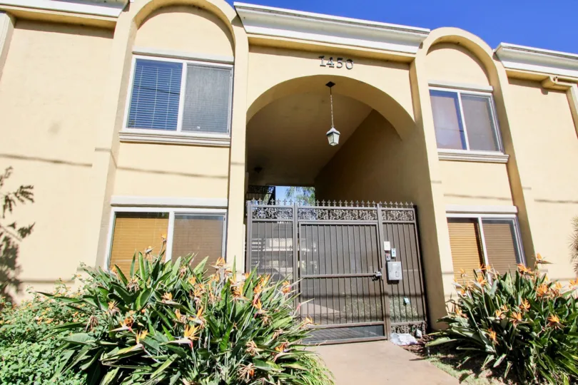 A sunny day in Tapestry has villa with number 1450 in a front view and bushes