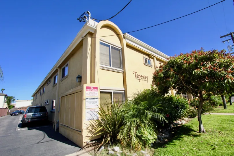 Outer view of the building in Tapestry with corner view of house, parking and garden.