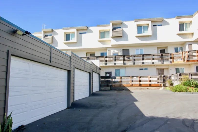 Three white garages inside of a single story gray structure in Imperial Beach CA at Vista De Coronado