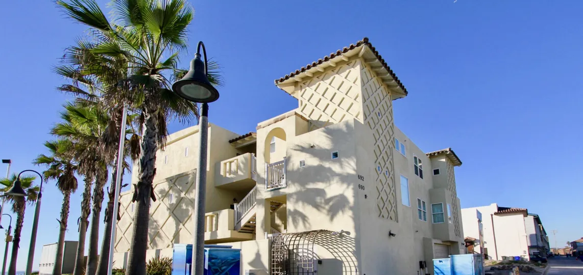 Three story residential building near palm trees at Wavecrest in Imperial Beach California