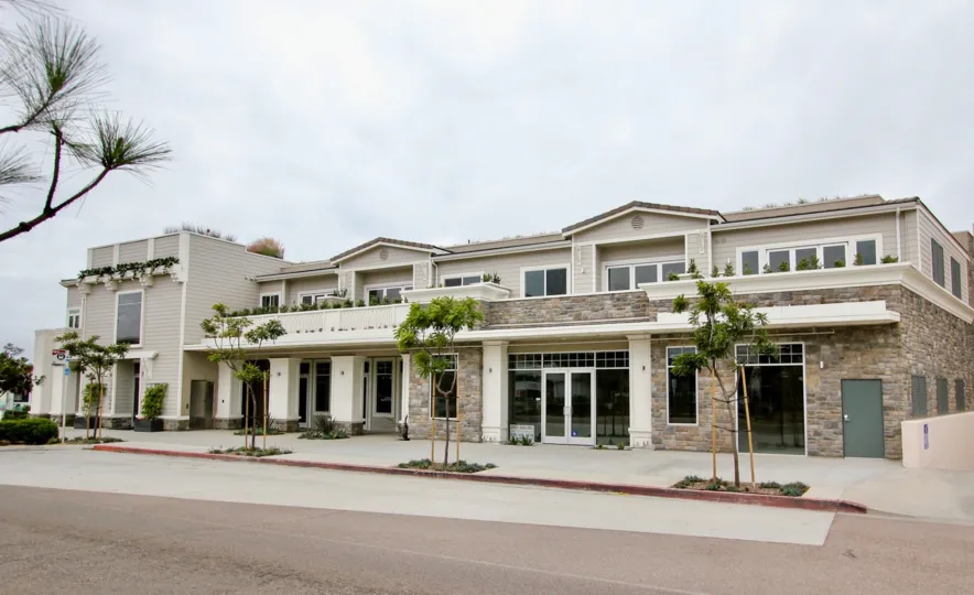 An adobe building with a manicured lawn on a clear day in 10 West
