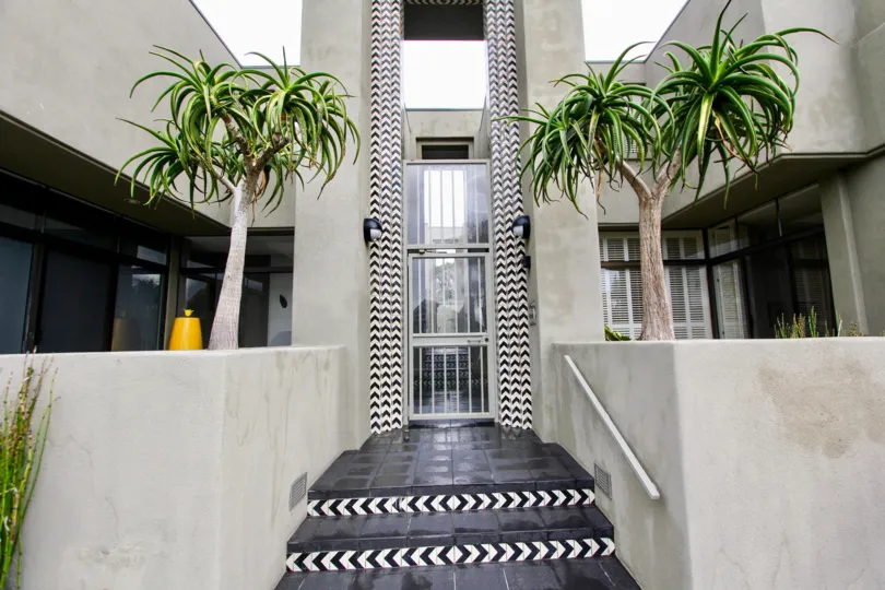 An entrance of a building in the 265 Coast with beautiful plants.
