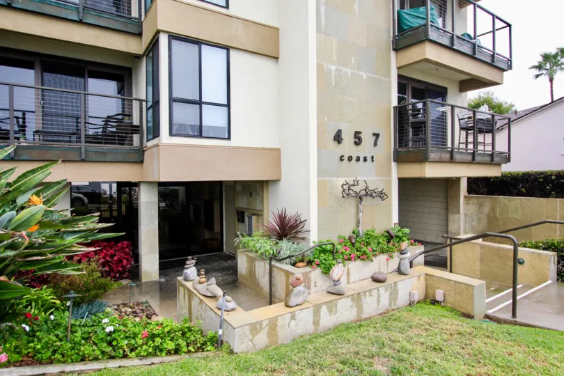 Three story housing with walkway lined with plants at 457 Coast in La Jolla California