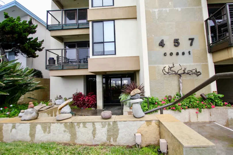 Modern styled building with decorative walls with stone artwork and stubwalls with earth tone colors in La Jolla
