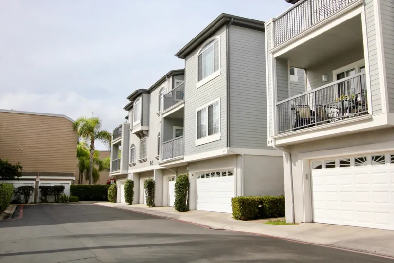 Gray residential units with white garage doors at Cape La Jolla Gardens in La Jolla California